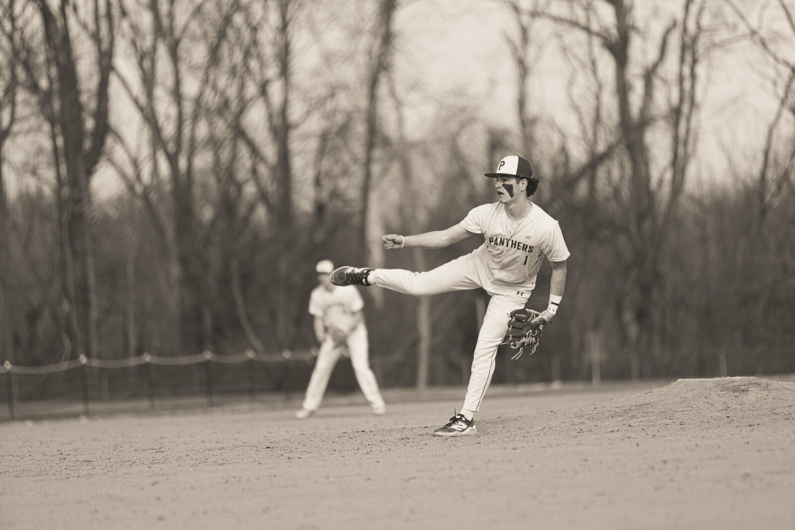 Sepia toned photo of an infielder throwing across the diamond