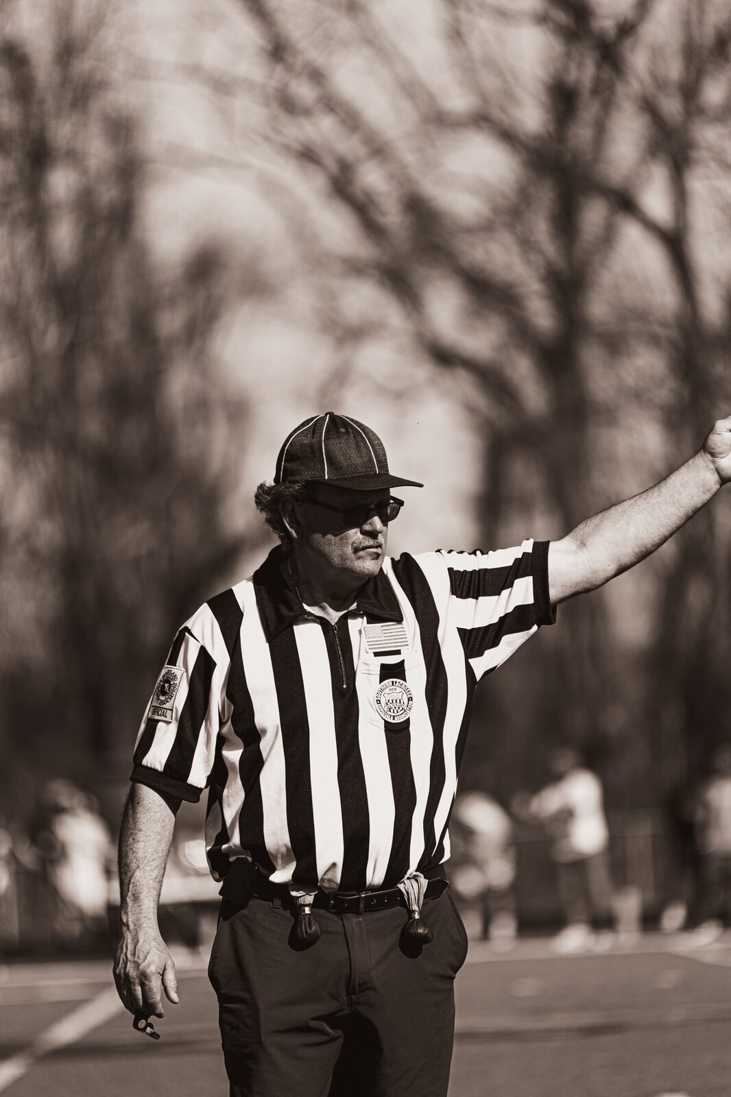 Warm toned photo of an umpire signaling a call with his arm out