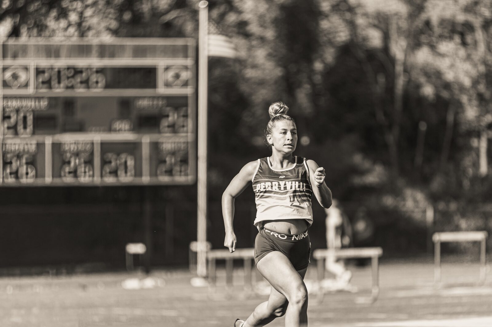 Black and white photo of a hurdler at full speed between hurdles