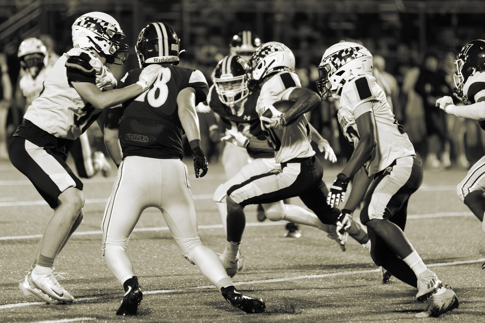 Black and white photo of offensive and defensive linemen colliding at the line of scrimmage