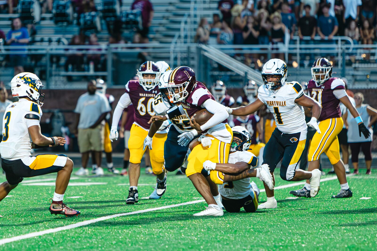 Ball carrier getting wrapped up by two defenders in the open field