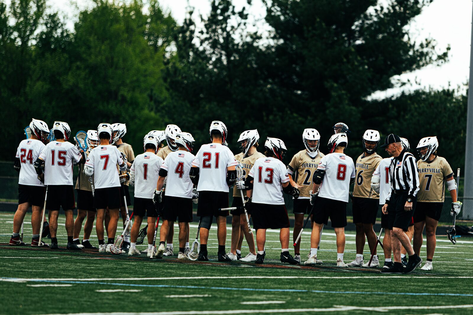 Lacrosse team gathered in a huddle at midfield before the opening faceoff