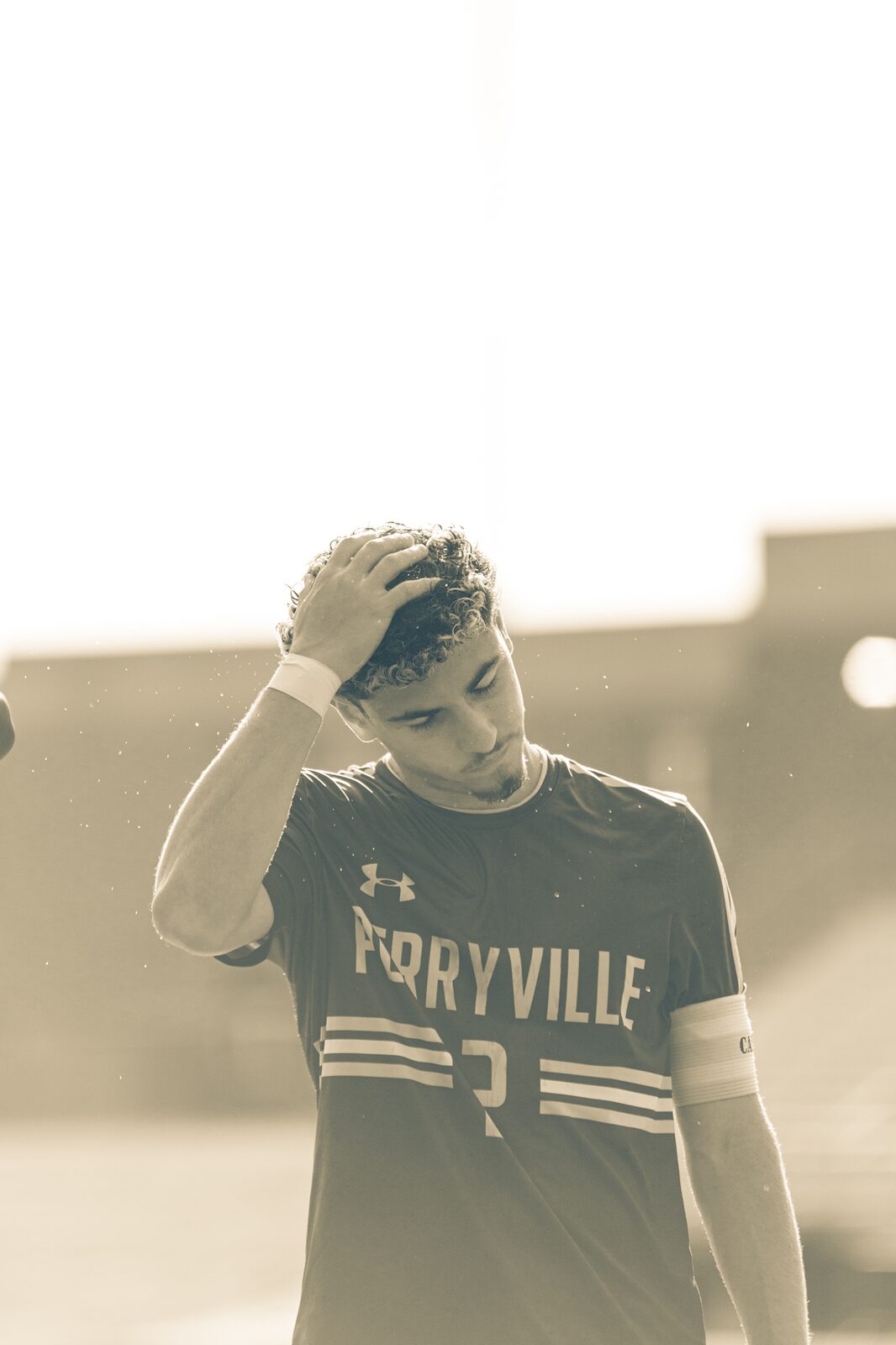 High key photo of a player with his hand on his head after a play