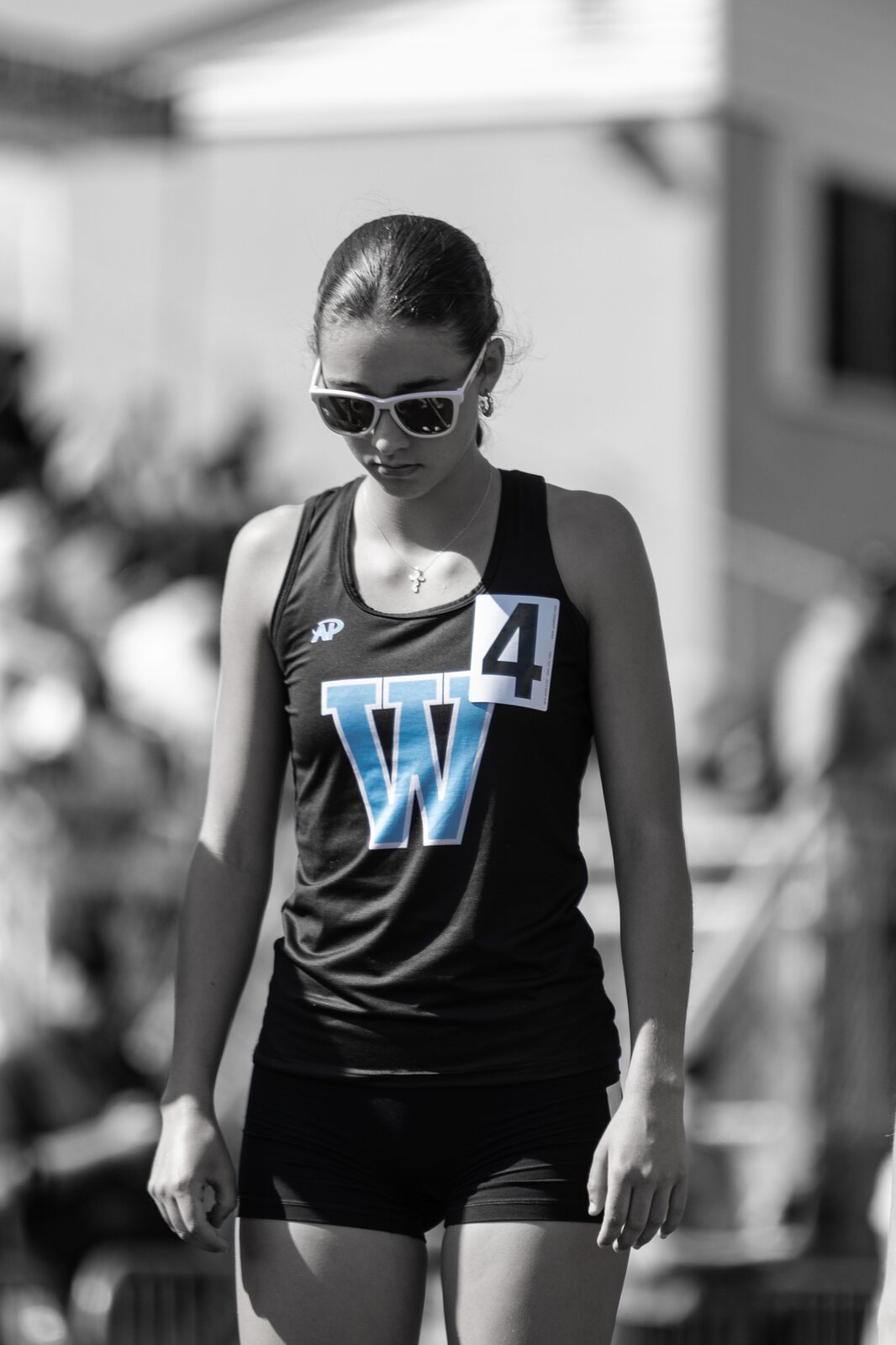 Black and white portrait of a runner in sunglasses waiting for her event