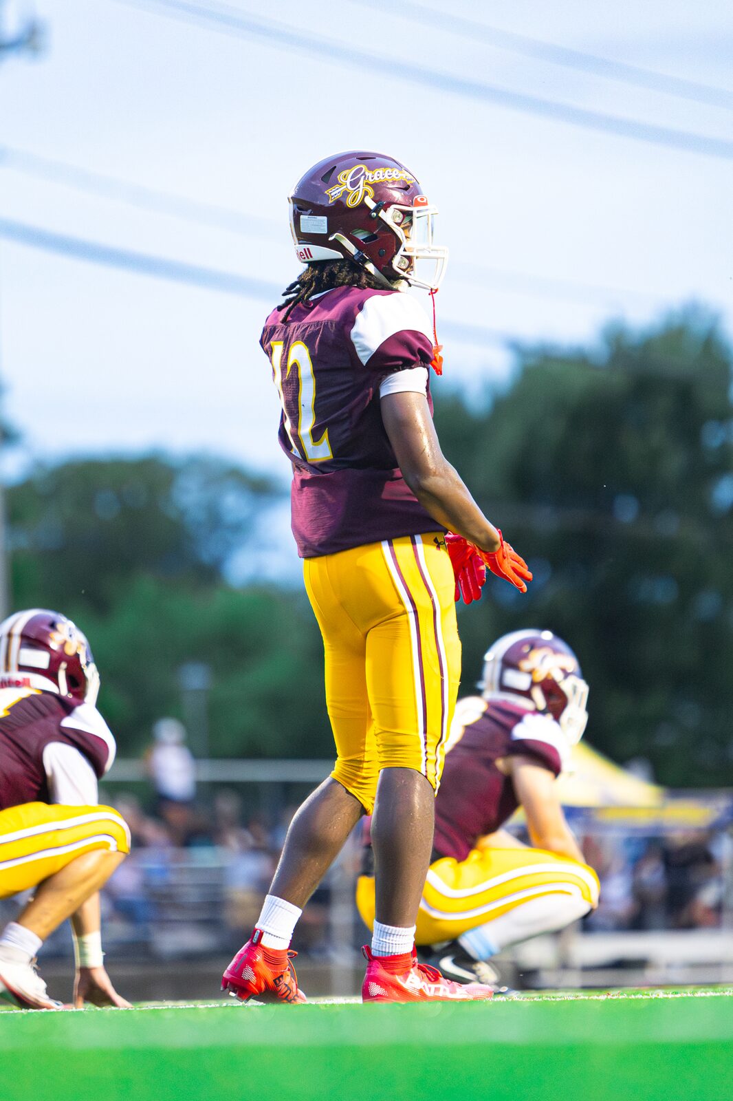 Running back standing tall on the field with teammates lined up behind him