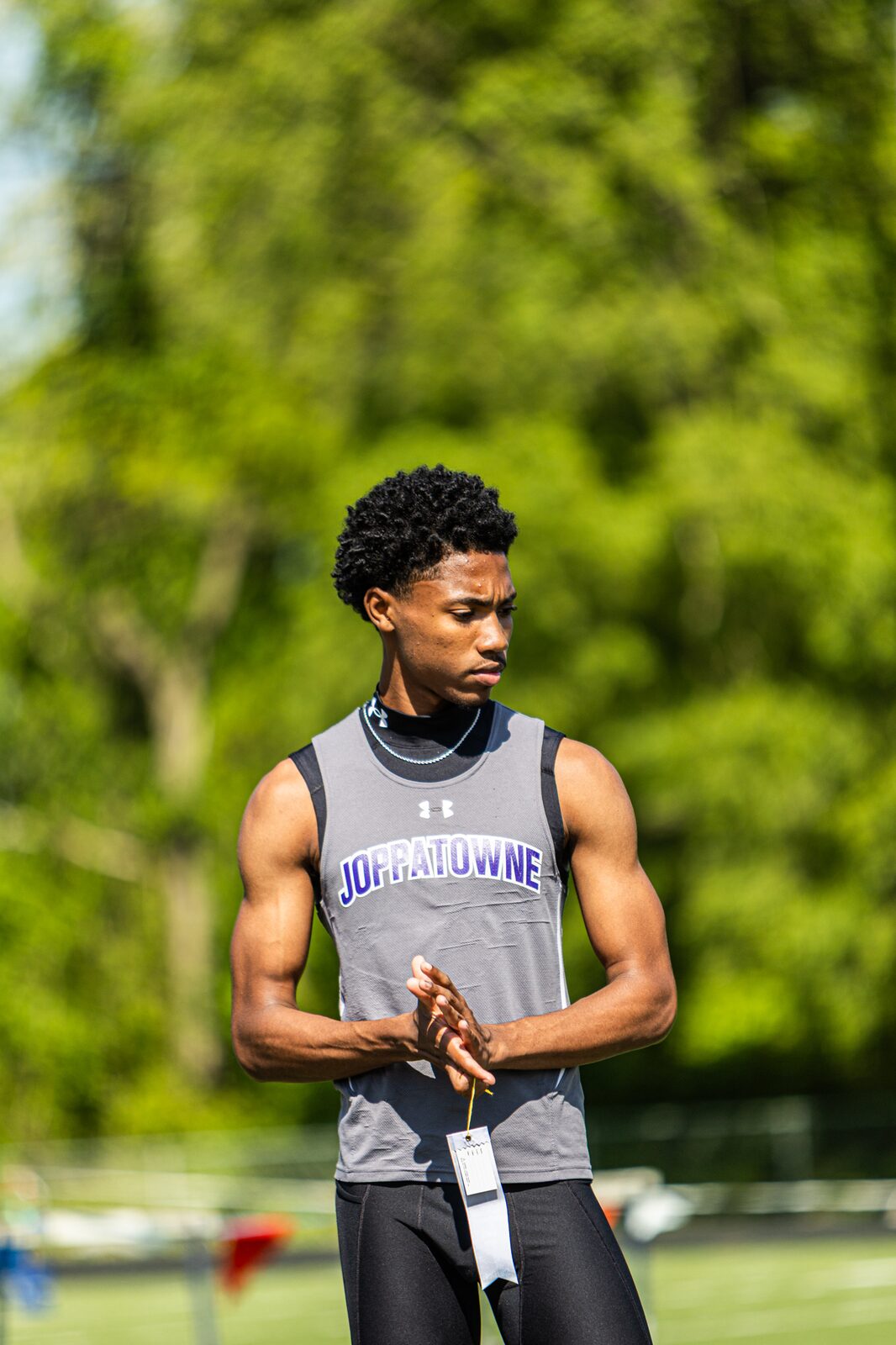 Runner standing with his race bib on, looking down the track before his heat