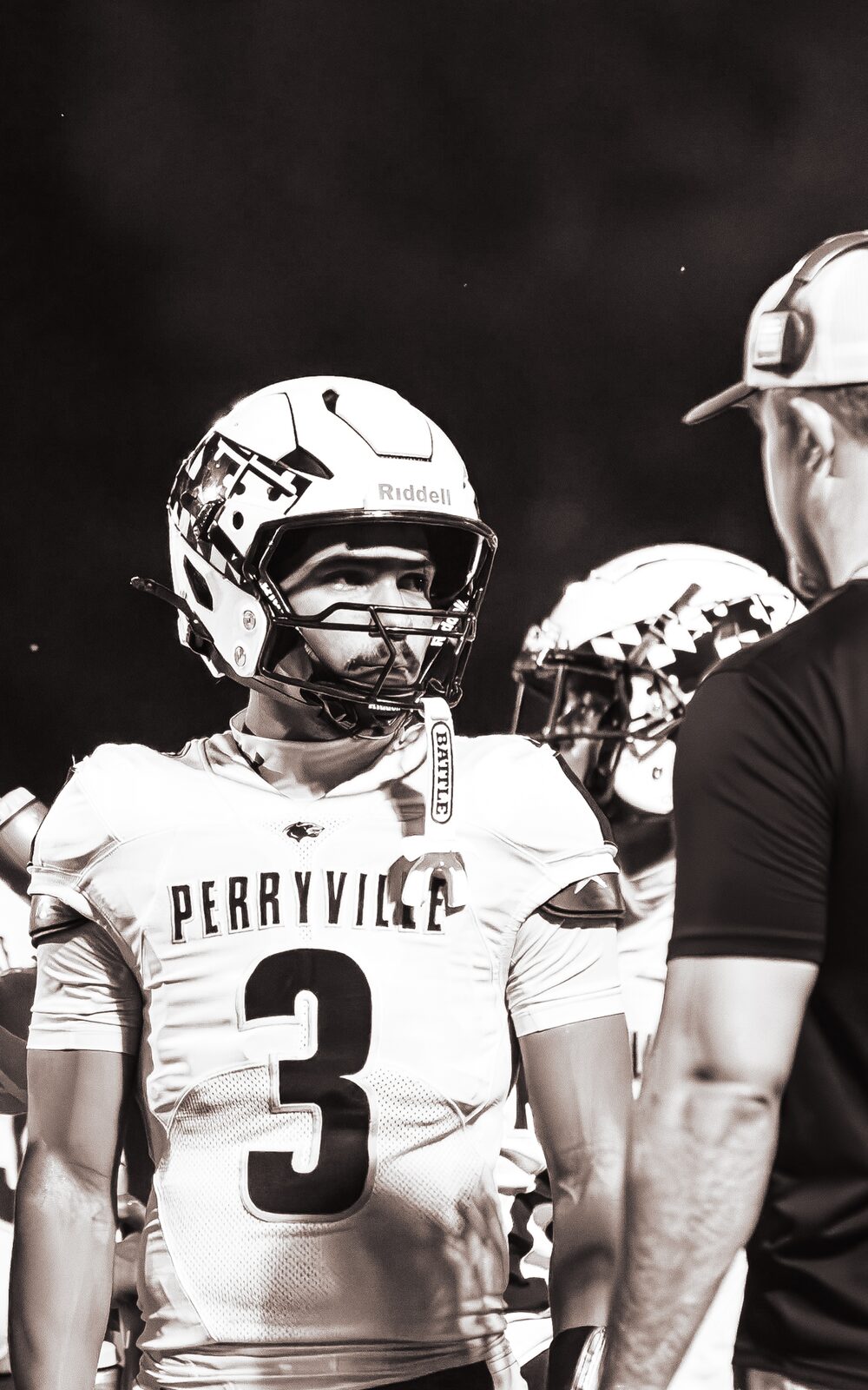 Warm toned portrait of a quarterback on the sideline between series