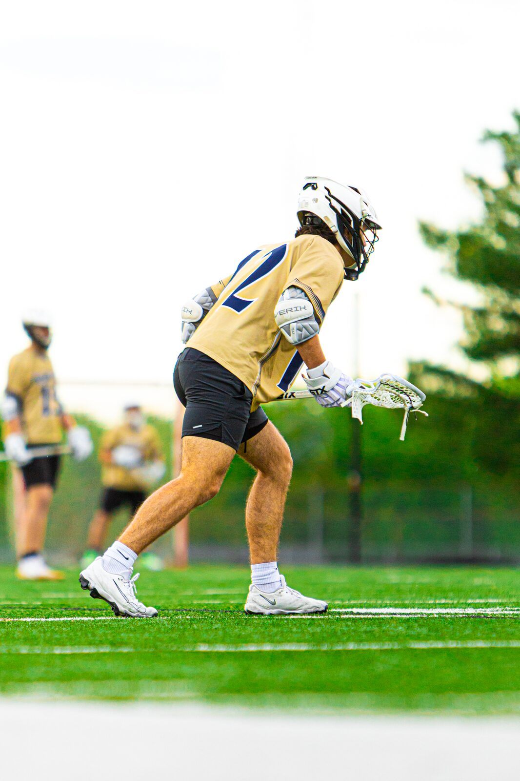 Lacrosse player winding up to shoot with his stick cocked behind his head